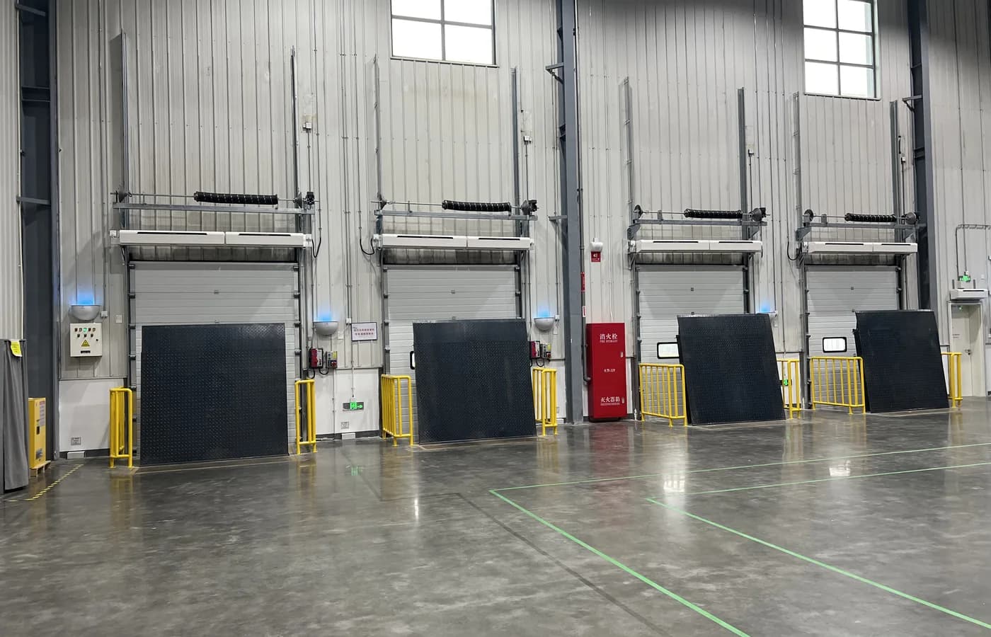Multiple SEPPES dock levelers installed below industrial loading-bay doors