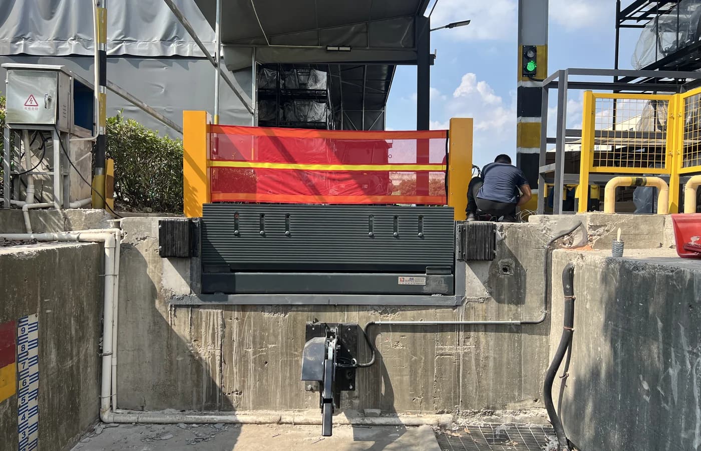 Hydraulic dock leveler with a red loading-bay safety barrier