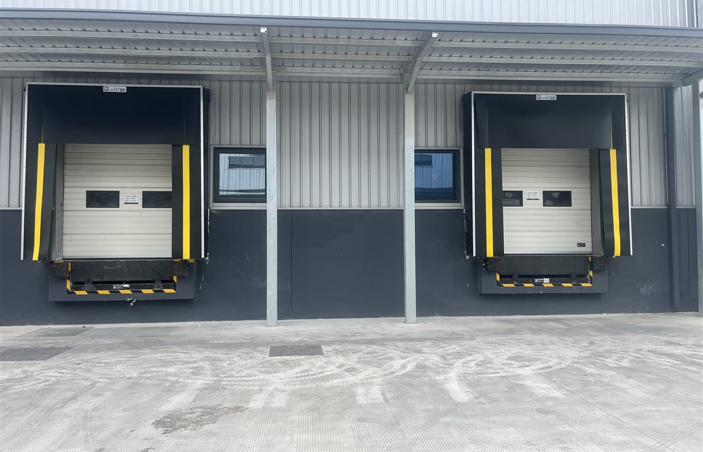 Two SEPPES dock shelters surrounding sectional doors at warehouse loading bays