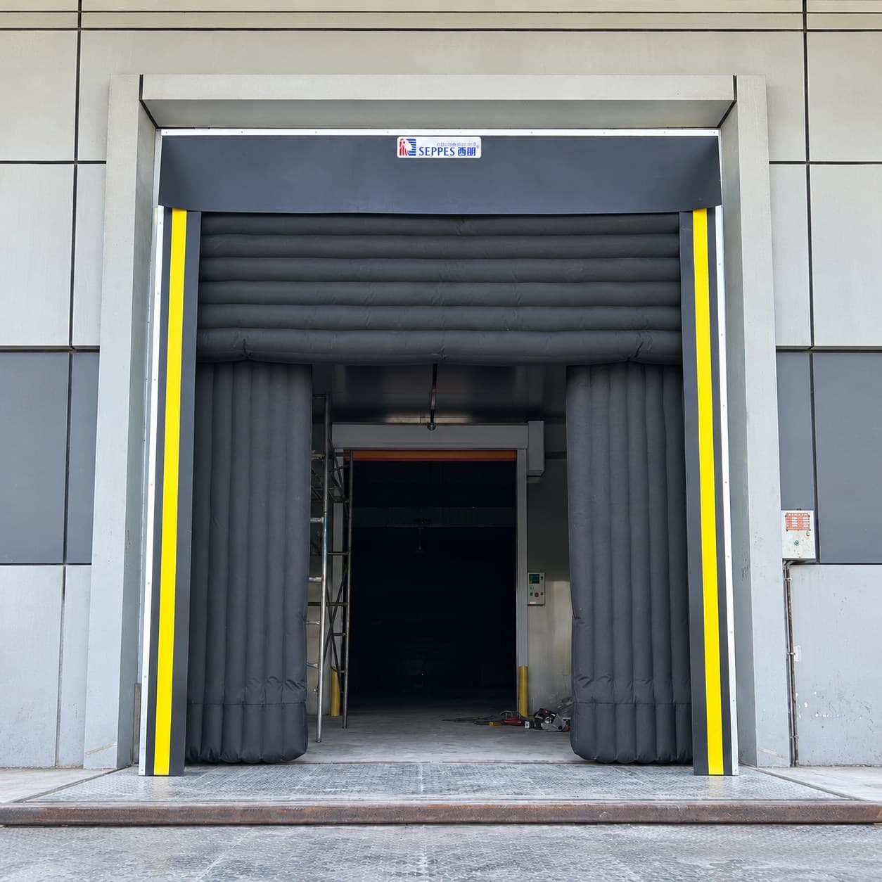 Inflatable dock shelter installed around a loading-bay opening