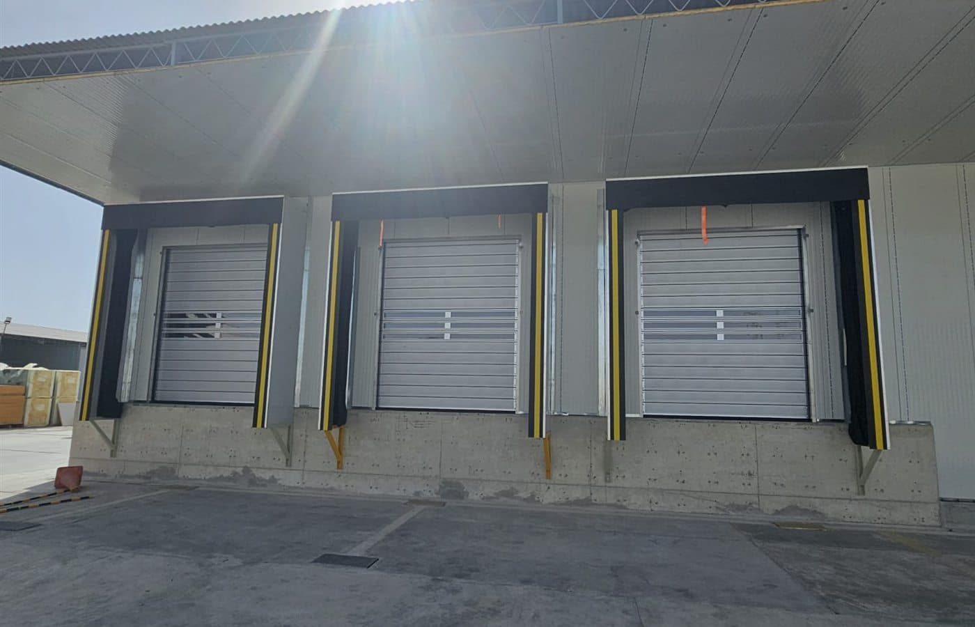 Three dock shelters coordinated with industrial doors at a warehouse loading area