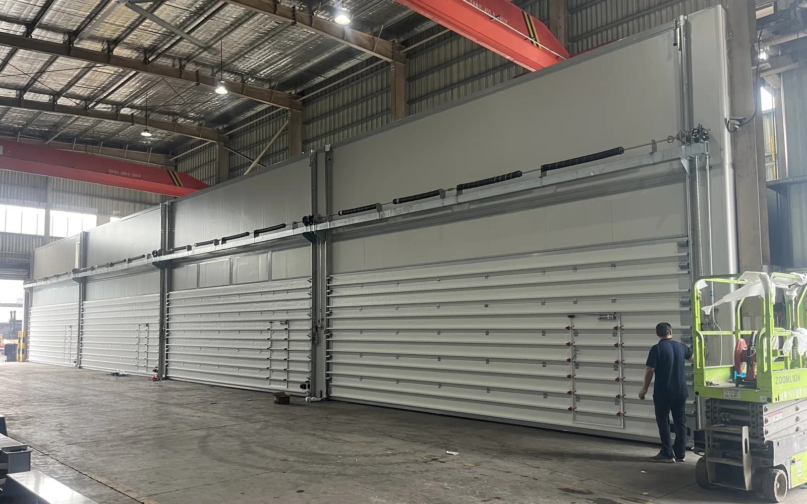 Industrial sectional door track and headroom arrangement inside a warehouse