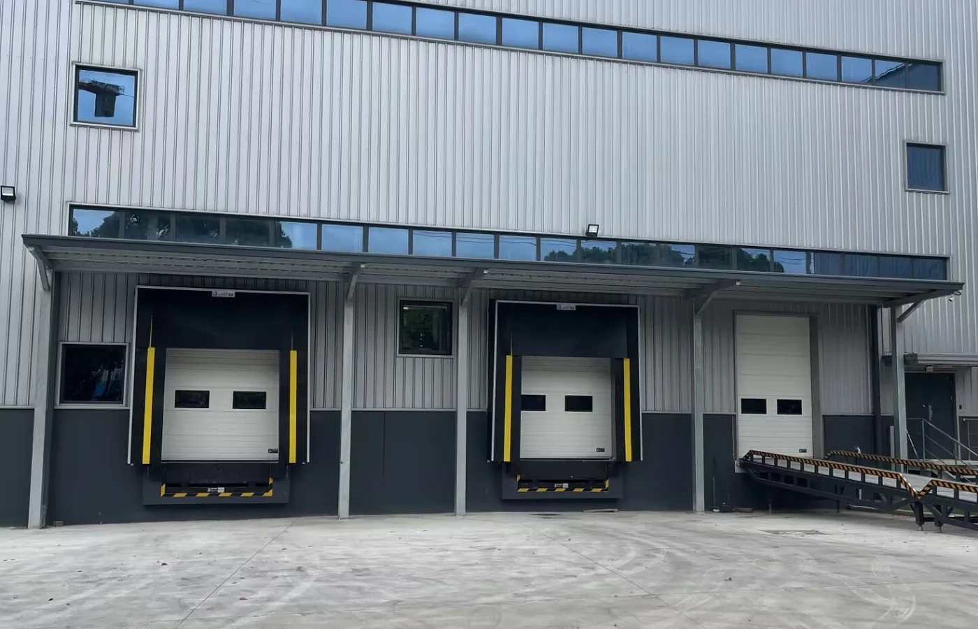 Integrated Door, Leveler and Shelter for a Logistics Loading Bay